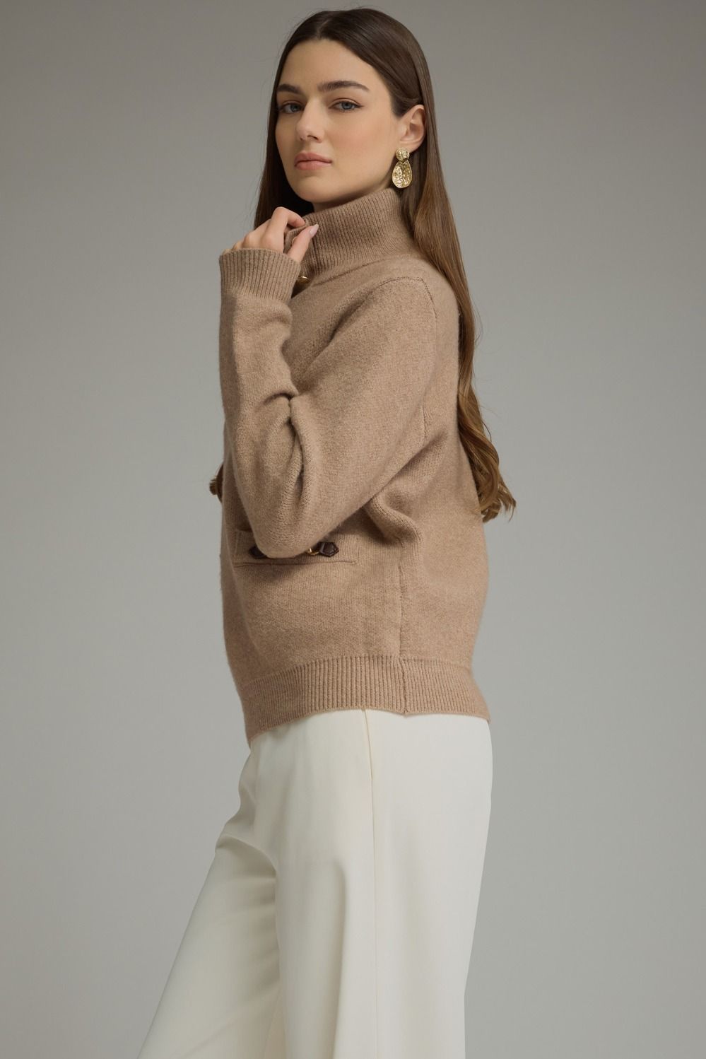 Solid long sleeve knit sweater top with stand neckline, button-front closure, and front pockets featuring buckle trim