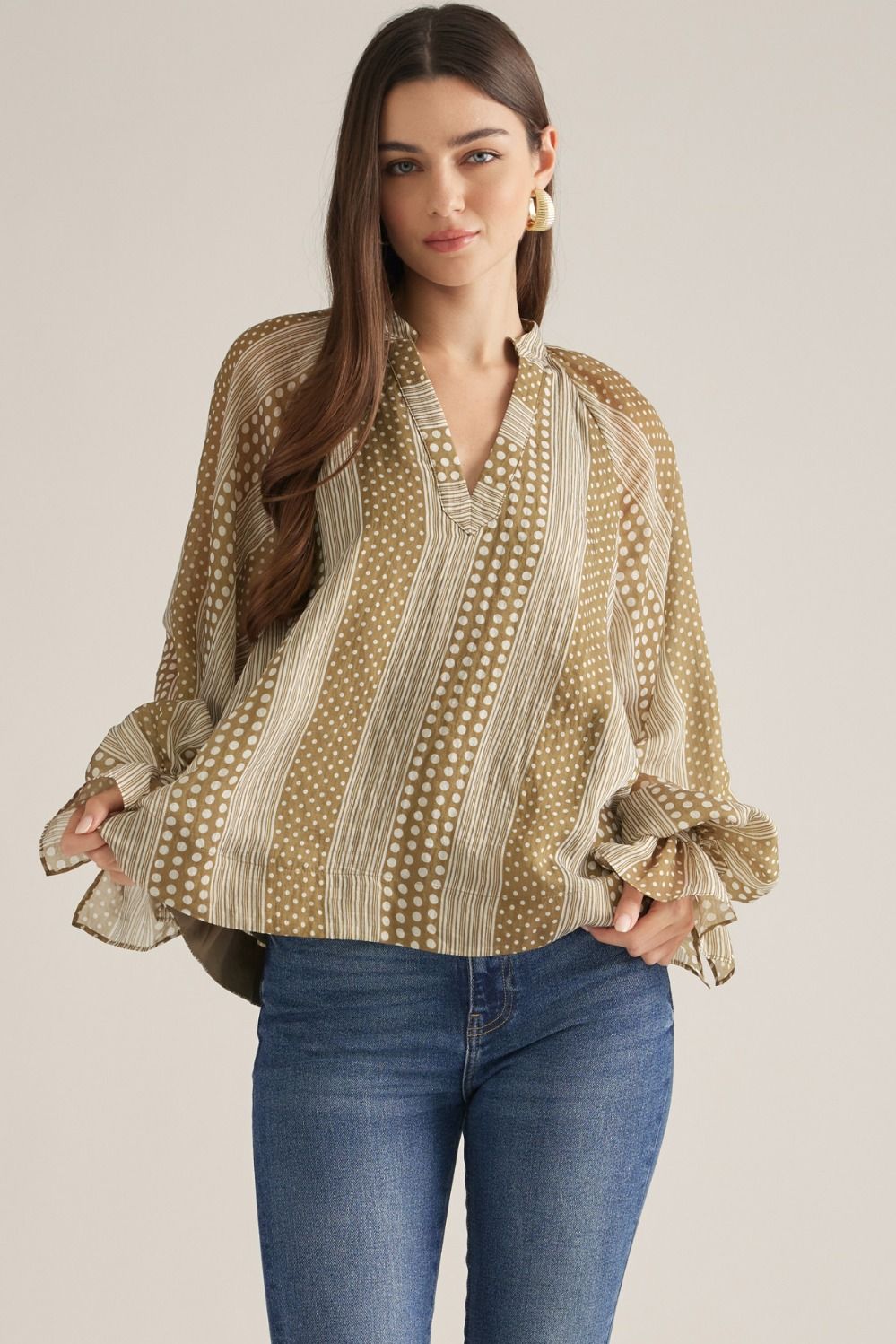 Women's mixed-print blouse featuring striped and polka dot patterns, V-neckline, long puff sleeves, and button-detail cuffs