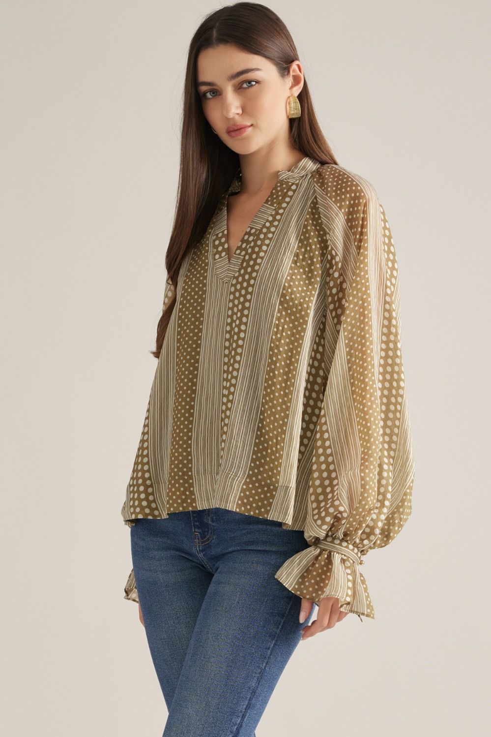 Women's mixed-print blouse featuring striped and polka dot patterns, V-neckline, long puff sleeves, and button-detail cuffs