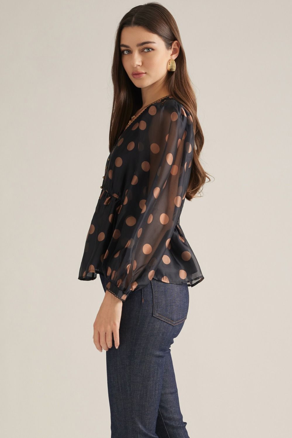 Women's polka dot woven top with V-neckline, long puff sleeves, decorative trim, button front, and elasticized back waist
