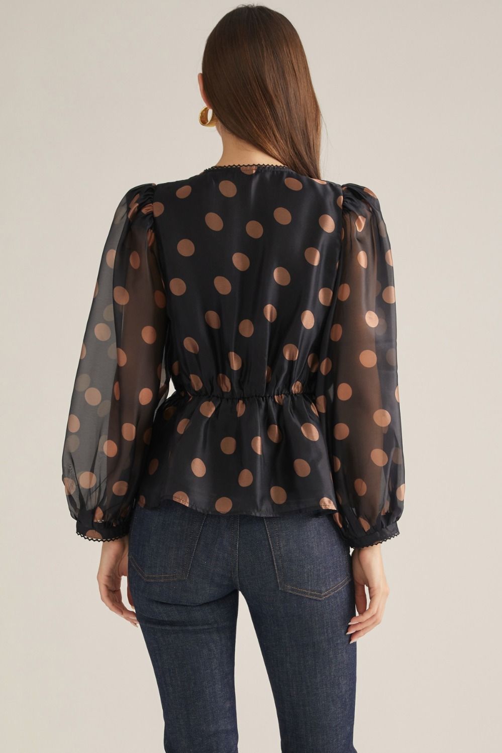 Women's polka dot woven top with V-neckline, long puff sleeves, decorative trim, button front, and elasticized back waist