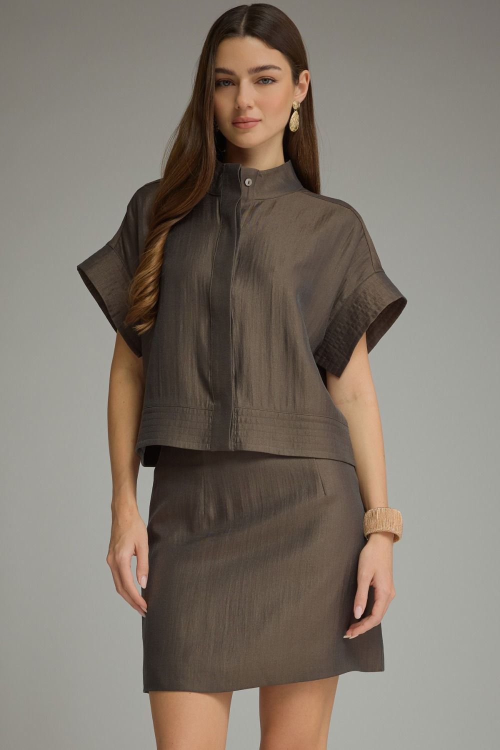 A polished two-piece set featuring a chic cropped top with wide cuffed sleeves paired with a sleek mini skirt for an effortlessly coordinated look.