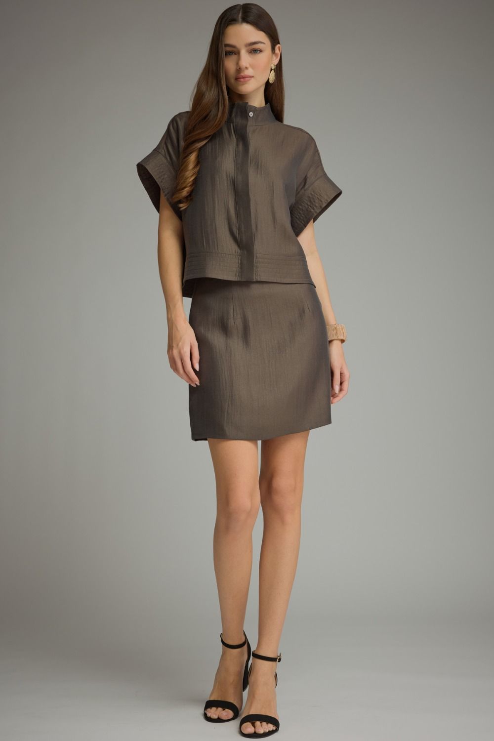 A polished two-piece set featuring a chic cropped top with wide cuffed sleeves paired with a sleek mini skirt for an effortlessly coordinated look.