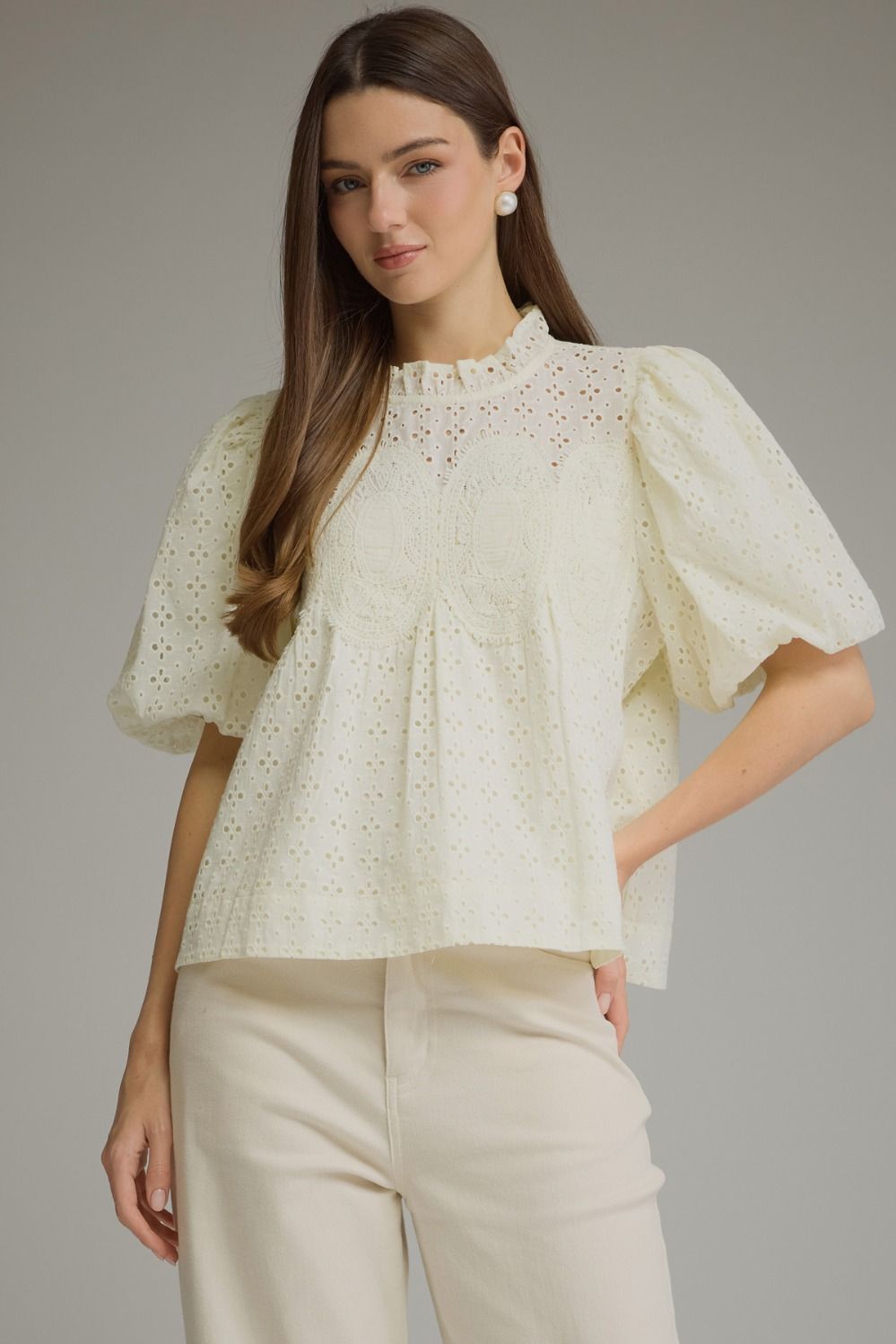 A feminine short sleeve top featuring a romantic ruffled neckline, delicate eyelet detailing, and crochet trim for a beautifully textured boutique look.