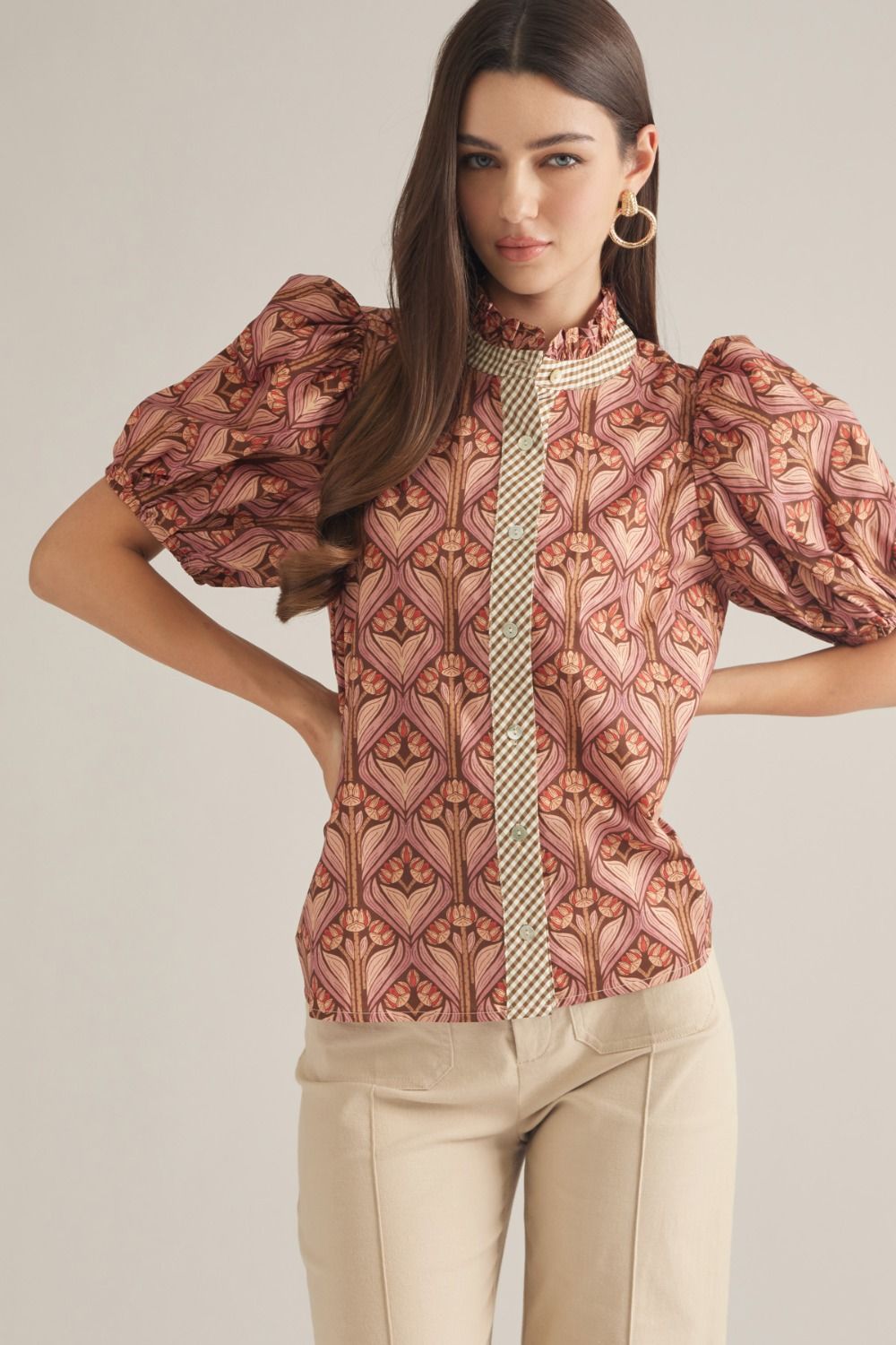 A feminine short sleeve top featuring a charming ruffled neckline, contrast trim, and button-front closure in a lightweight woven fabric.