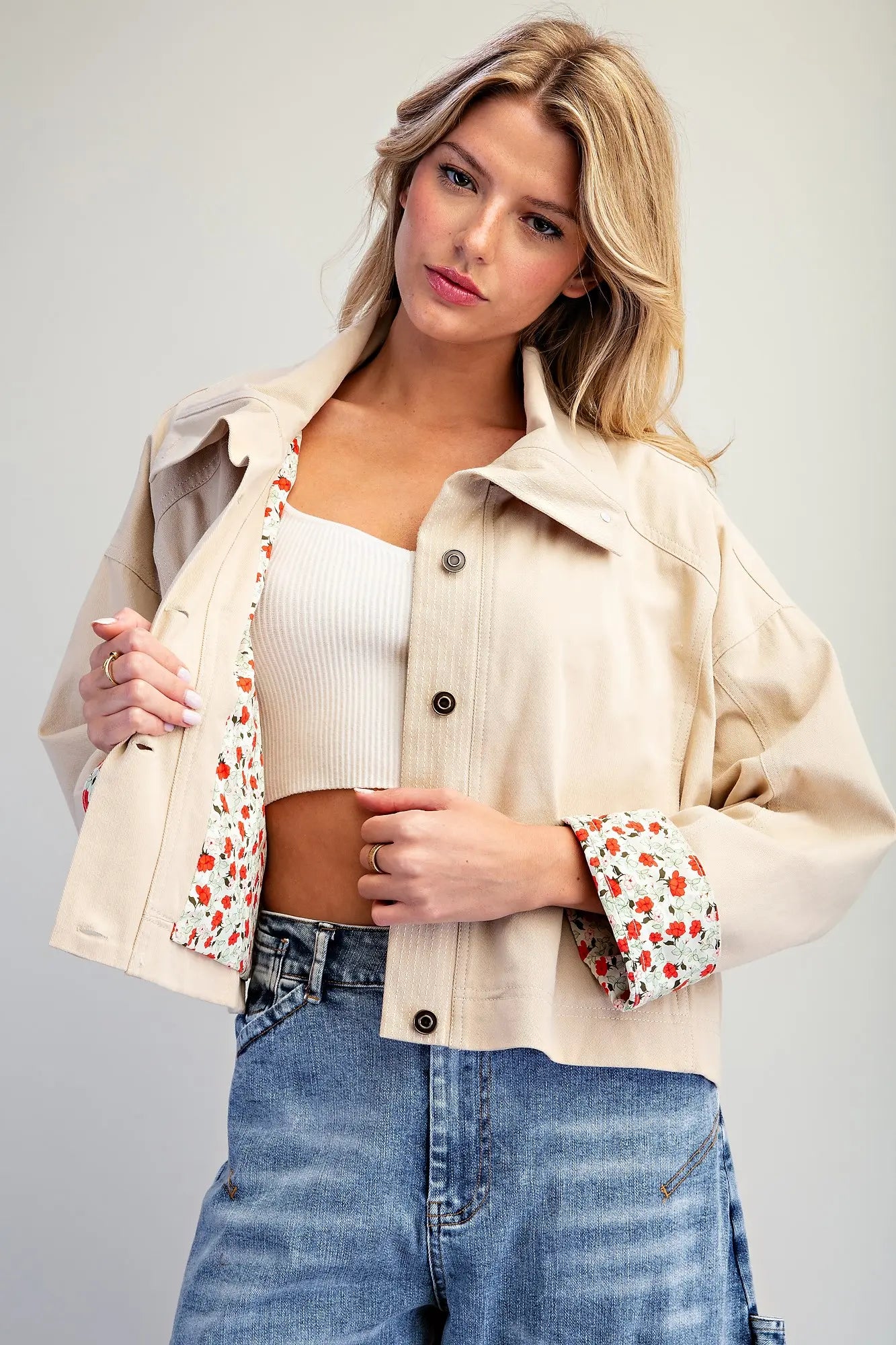 The Marjorie Floral Lined Cropped Jacket pairs a relaxed beige silhouette with a vibrant floral lining for a sophisticated statement layer with a playful twist.
