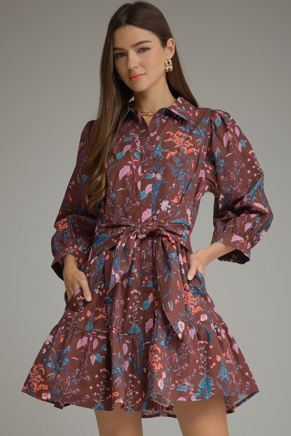 A charming floral mini dress featuring ¾ balloon sleeves, a classic shirt collar, self-tie waist, and playful tiered hem.
