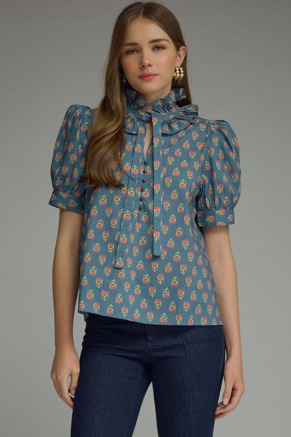  printed puff sleeve blouse features a feminine ruffle neckline, self-tie detail, and timeless button-front styling.
