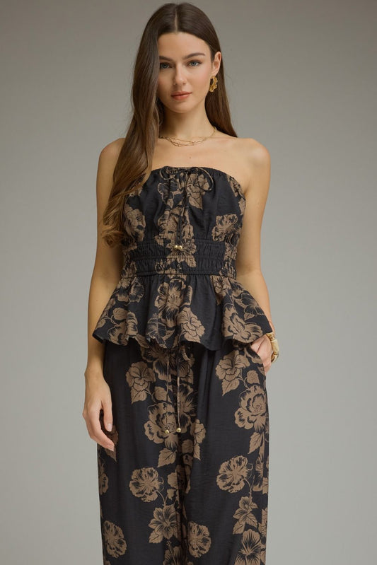 A feminine floral peplum top featuring a straight neckline, adjustable tie straps, smocked waist, and lightweight lined design for effortless summer style.