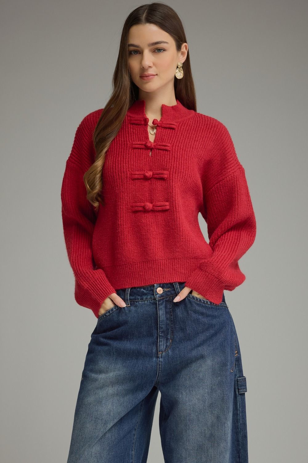 A cozy, polished sweater featuring a high neckline, statement frog-button closure, and relaxed drop shoulders for timeless style with a modern twist.

