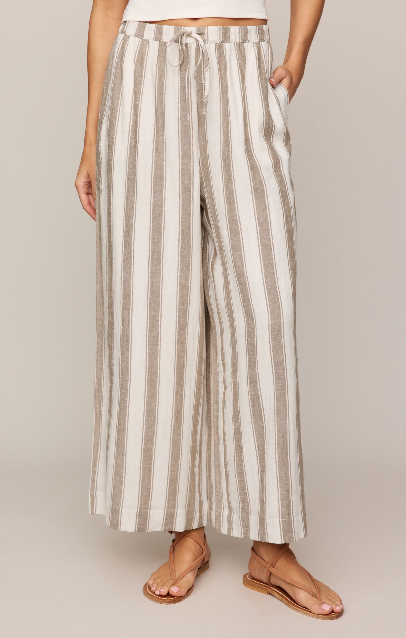 Effortlessly chic and breathable, these striped linen-blend pants feature a high-rise fit, adjustable drawcord waist, and relaxed ankle-length silhouette.
