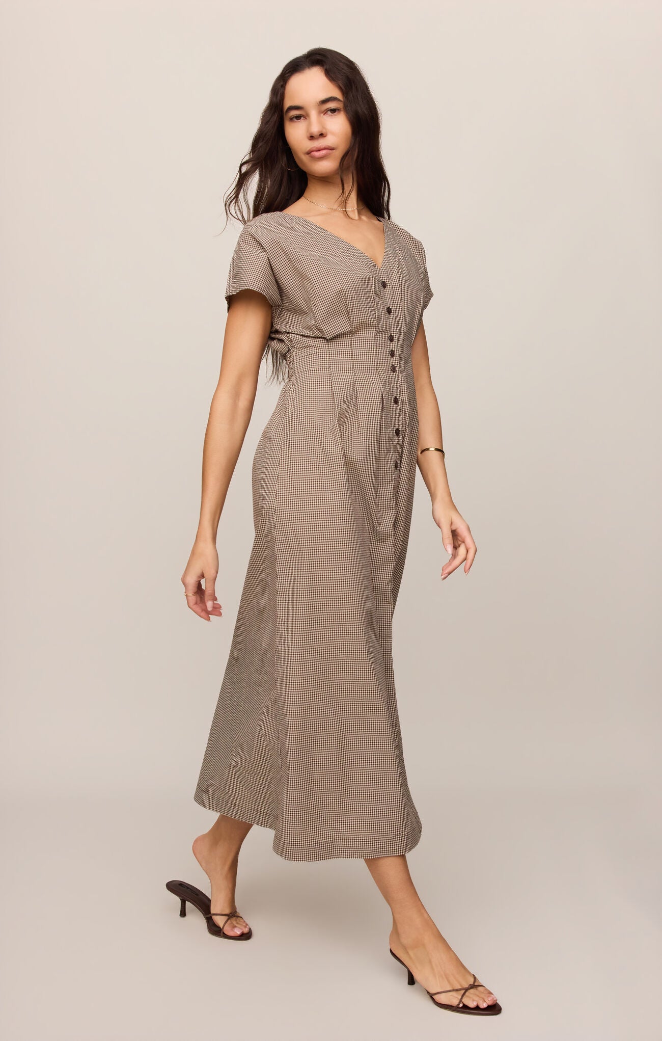 A cotton poplin shirt dress featuring a classic gingham print, flattering V-neckline, and button-front design for effortless everyday sophistication.
