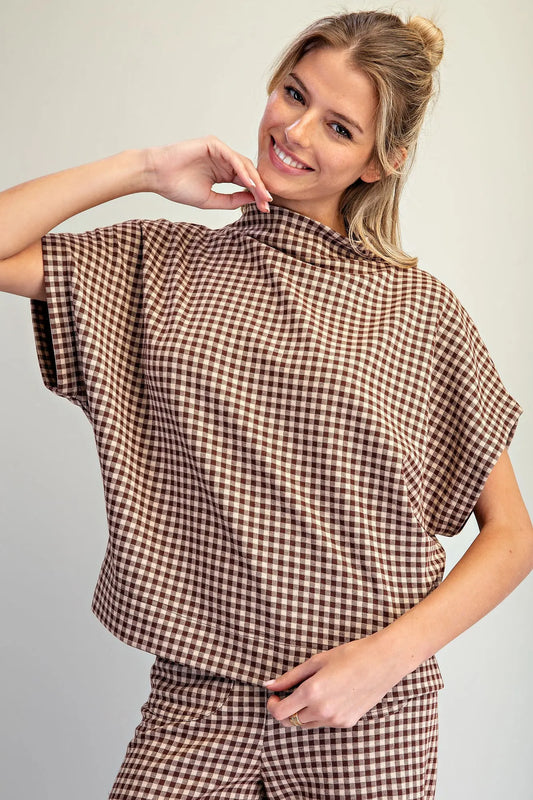 A relaxed gingham knit top featuring a modern mock neckline, wide dolman sleeves, and an effortlessly chic oversized silhouette.