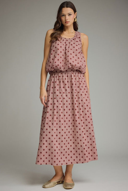 A charming gingham polka dot sleeveless top featuring a gathered neckline, elastic hem, and lightweight lined design for effortless feminine style.

