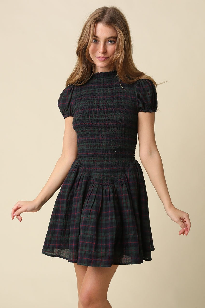 A timeless plaid mini dress featuring a flattering smocked bodice, feminine cap sleeves, and a softly gathered fit-and-flare skirt in breathable cotton.