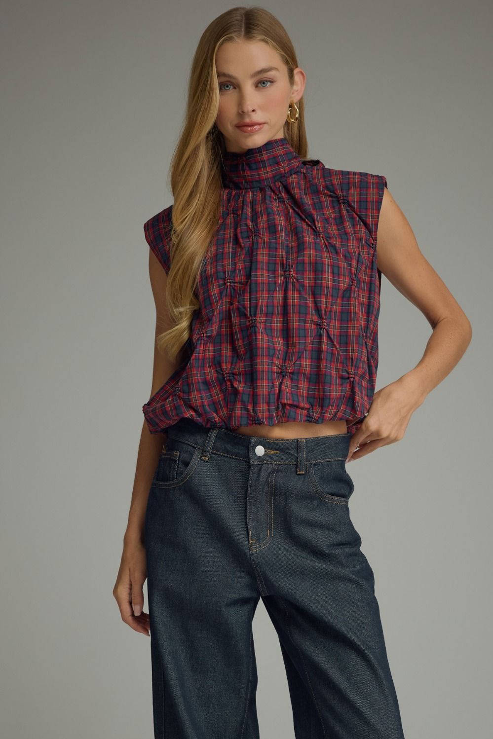 The Eleanor Plaid Top pairs a classic plaid pattern with feminine texture, a high neckline, and a playful bubble hem for a fresh, elevated look.