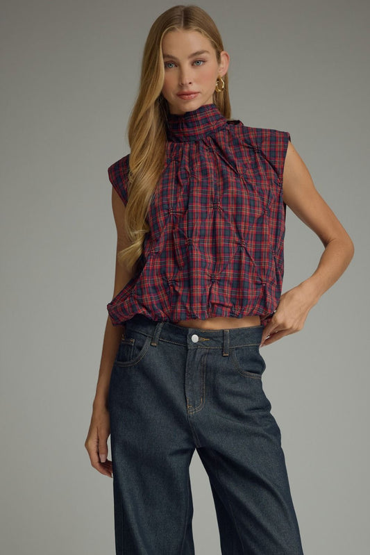 The Eleanor Plaid Top pairs a classic plaid pattern with feminine texture, a high neckline, and a playful bubble hem for a fresh, elevated look.