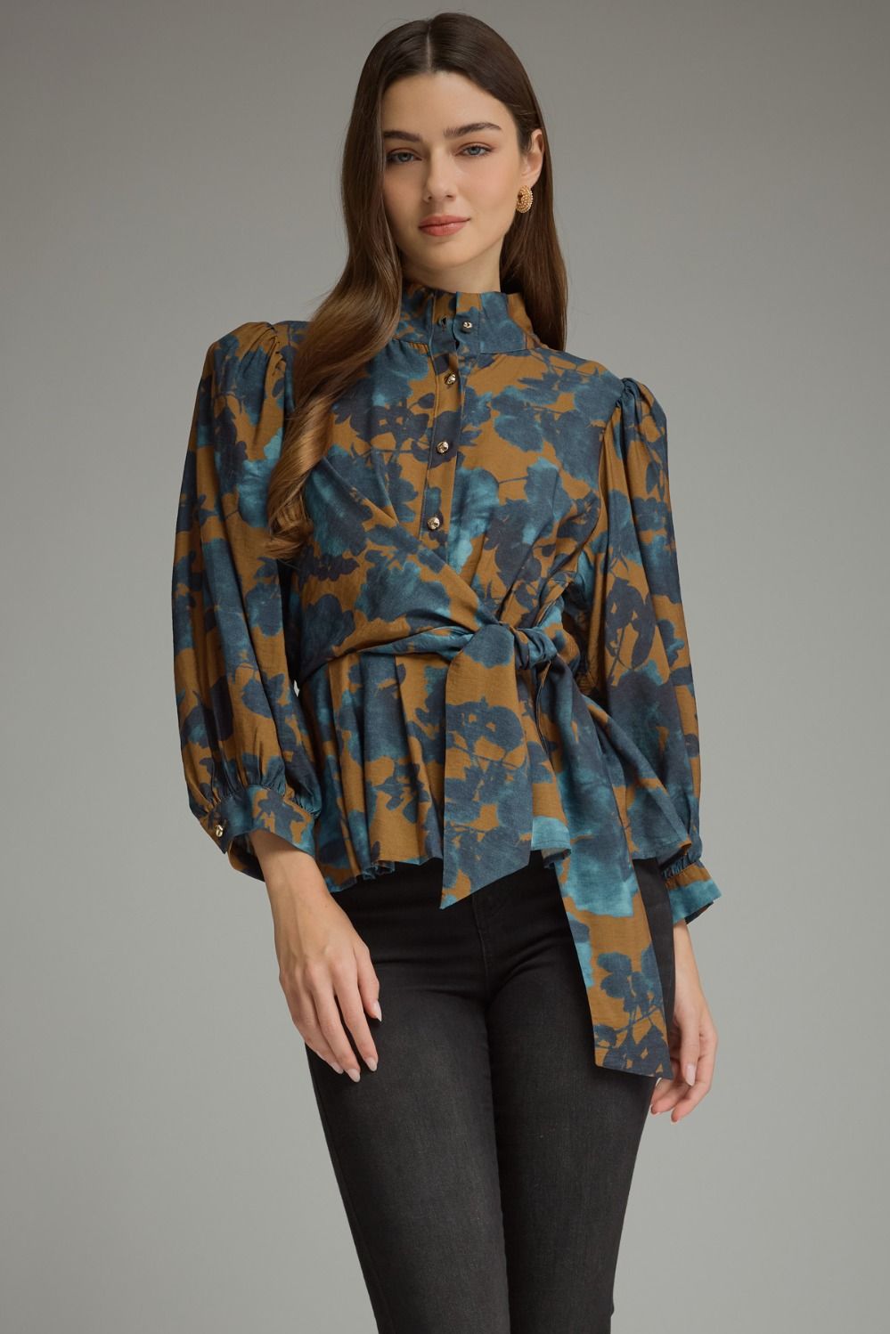 A feminine floral peplum top featuring romantic balloon sleeves, a stand collar, and a flattering tie waist for a beautifully defined silhouette.a