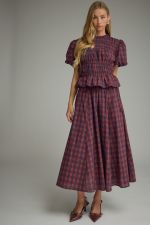 A timeless plaid midi skirt featuring flattering gathered detail, a comfortable elastic-back waist, and practical side pockets.
