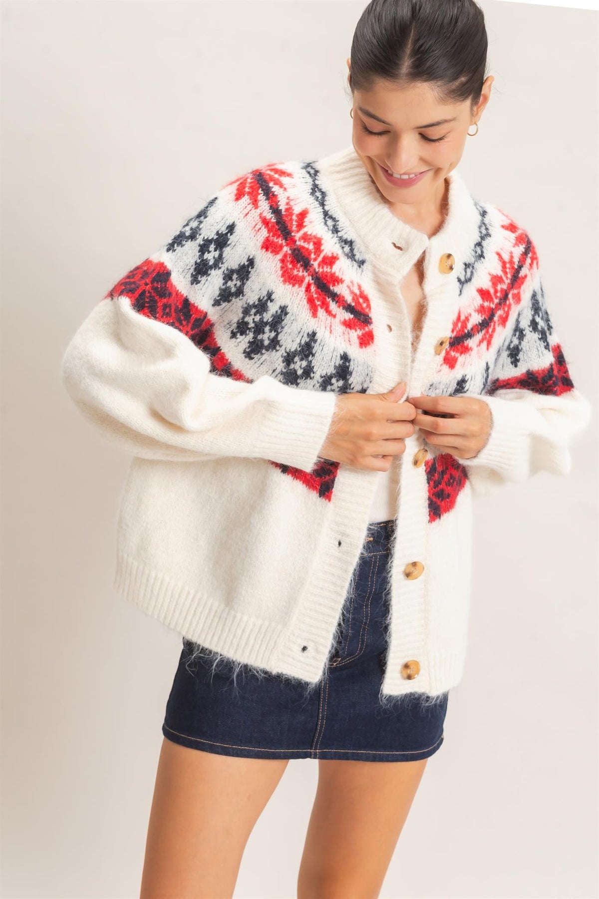 A cozy Fair Isle cardigan featuring classic snowflake motifs, a soft fuzzy texture, and a relaxed button-front silhouette perfect for chilly days.