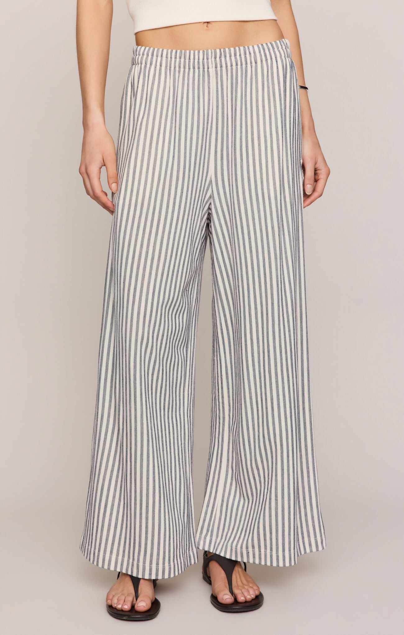 Women’s high-rise wide-leg ankle pants in silky stretch knit fabric with elastic waistband, slash pockets, lightweight design, and ultra-soft finish.