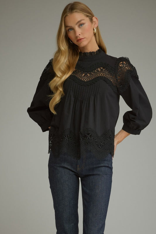 A romantic ¾ sleeve top featuring elegant pintuck detailing, delicate lace trim, and a refined mock neckline.