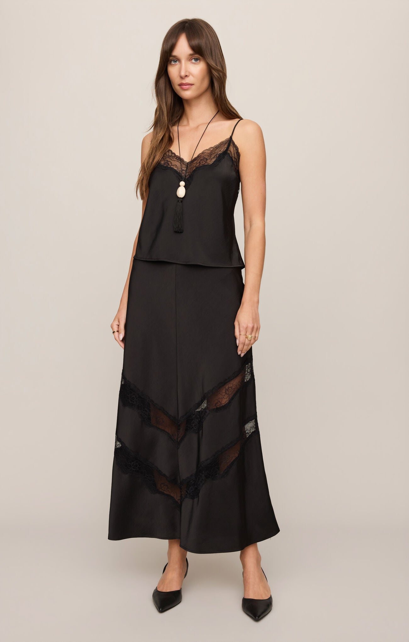 The Kori Lace Inset Skirt combines luxe satin with a flattering high-rise fit and elegant lace detailing for an effortlessly feminine statement.