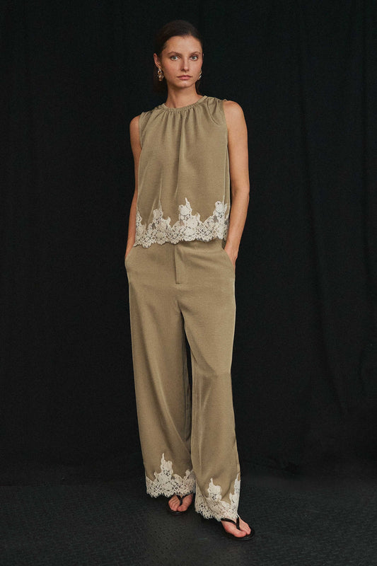 An effortlessly elegant two-piece set featuring delicate lace trim, a gathered neckline, and flowing wide-leg pants for timeless sophistication.
