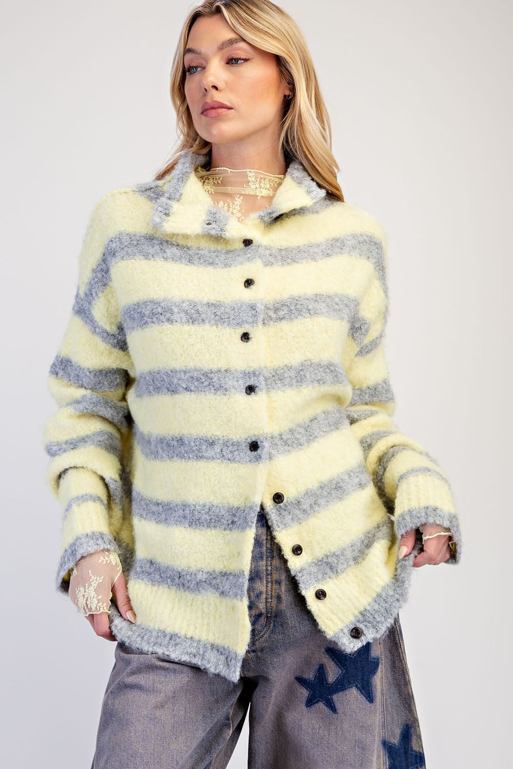 A cozy textured knit cardigan featuring a relaxed slouchy fit, dropped shoulders, and playful mismatched buttons for a unique finishing touch.