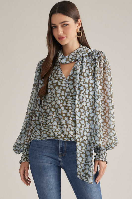 A chic leopard print top featuring dramatic balloon sleeves, a feminine self-tie neckline, and comfortable smocked cuffs for an effortlessly stylish look.