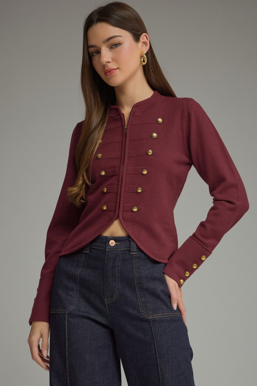 A polished knit jacket featuring a classic round neckline, zip-front closure, decorative buttons, and refined button details at the cuffs.


