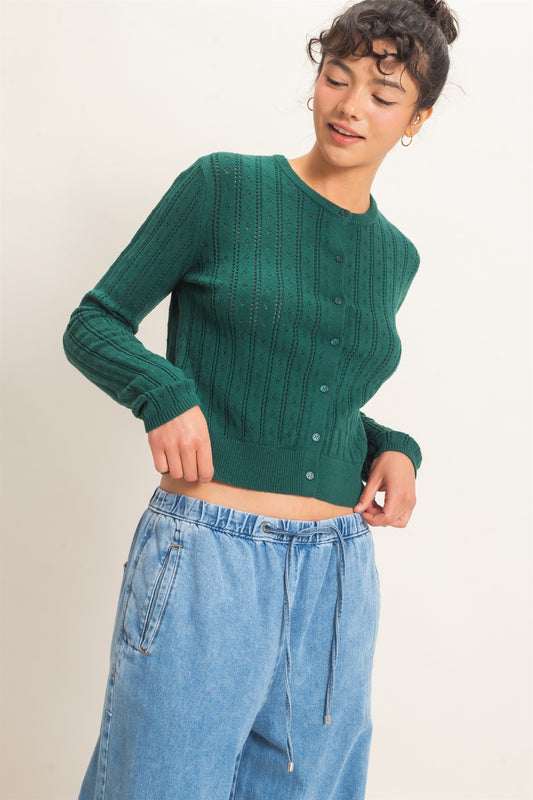 A timeless pointelle knit cardigan featuring a classic button-front design, ribbed crew neckline, and a tailored silhouette for effortless everyday elegance.