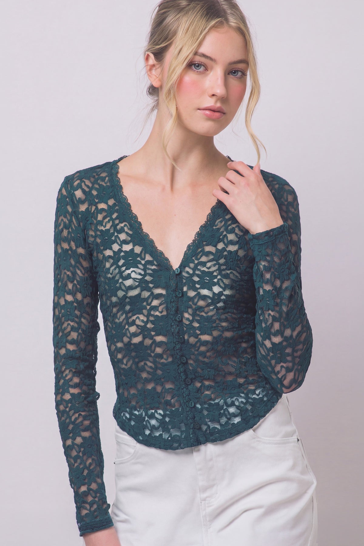 A romantic sheer floral lace top featuring long sleeves, a scalloped V-neckline, delicate trim details, and matching front buttons for an effortlessly feminine look.