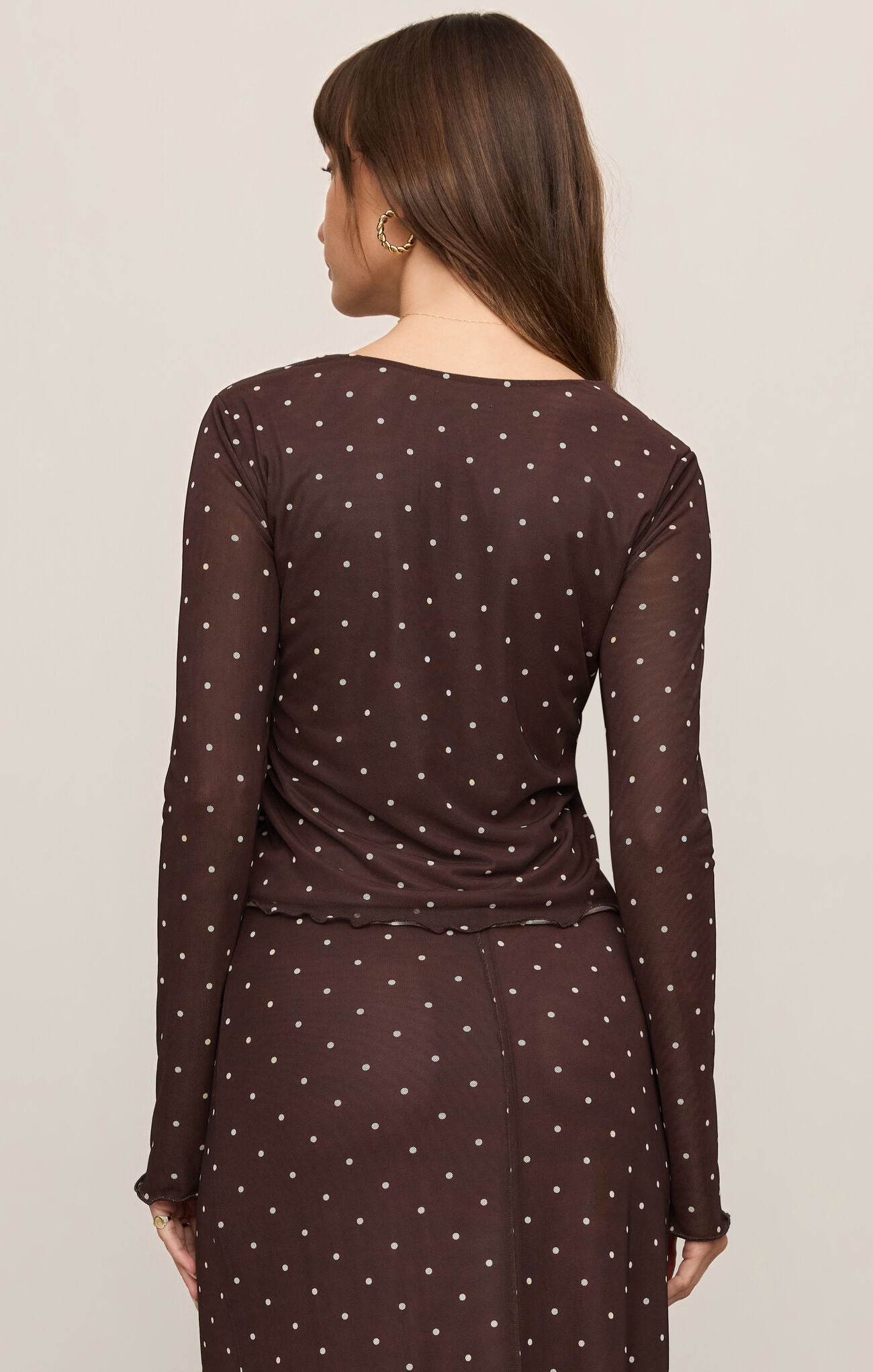 A sleek mesh V-neck top featuring a lightweight stretch fabric, long sleeves, and a flattering silhouette perfect for layering or making a statement.