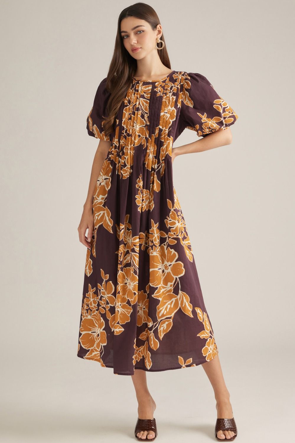 A feminine floral midi dress featuring romantic puff sleeves, a classic round neckline, and elegant front pleating for a beautifully polished silhouette.