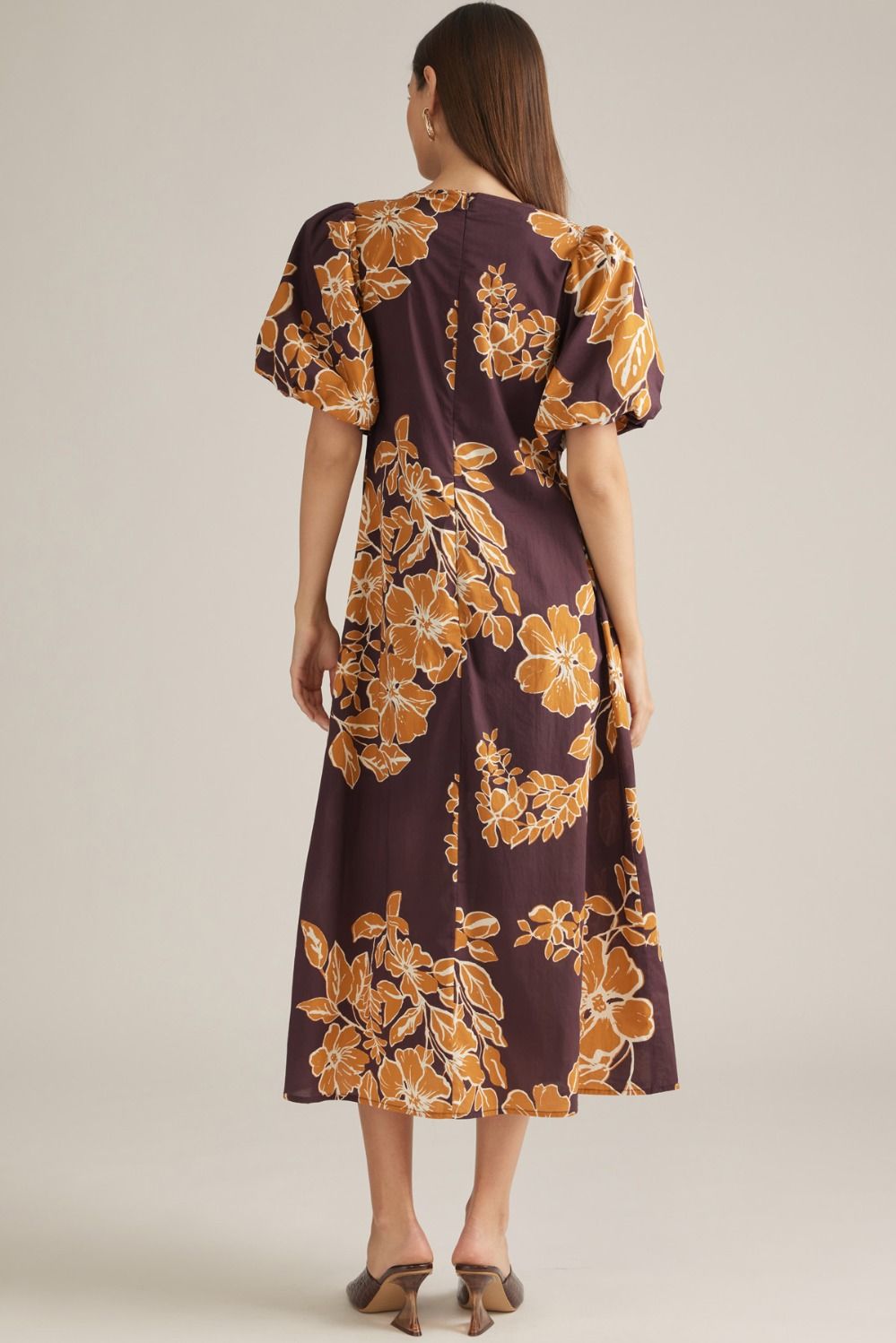 A feminine floral midi dress featuring romantic puff sleeves, a classic round neckline, and elegant front pleating for a beautifully polished silhouette.