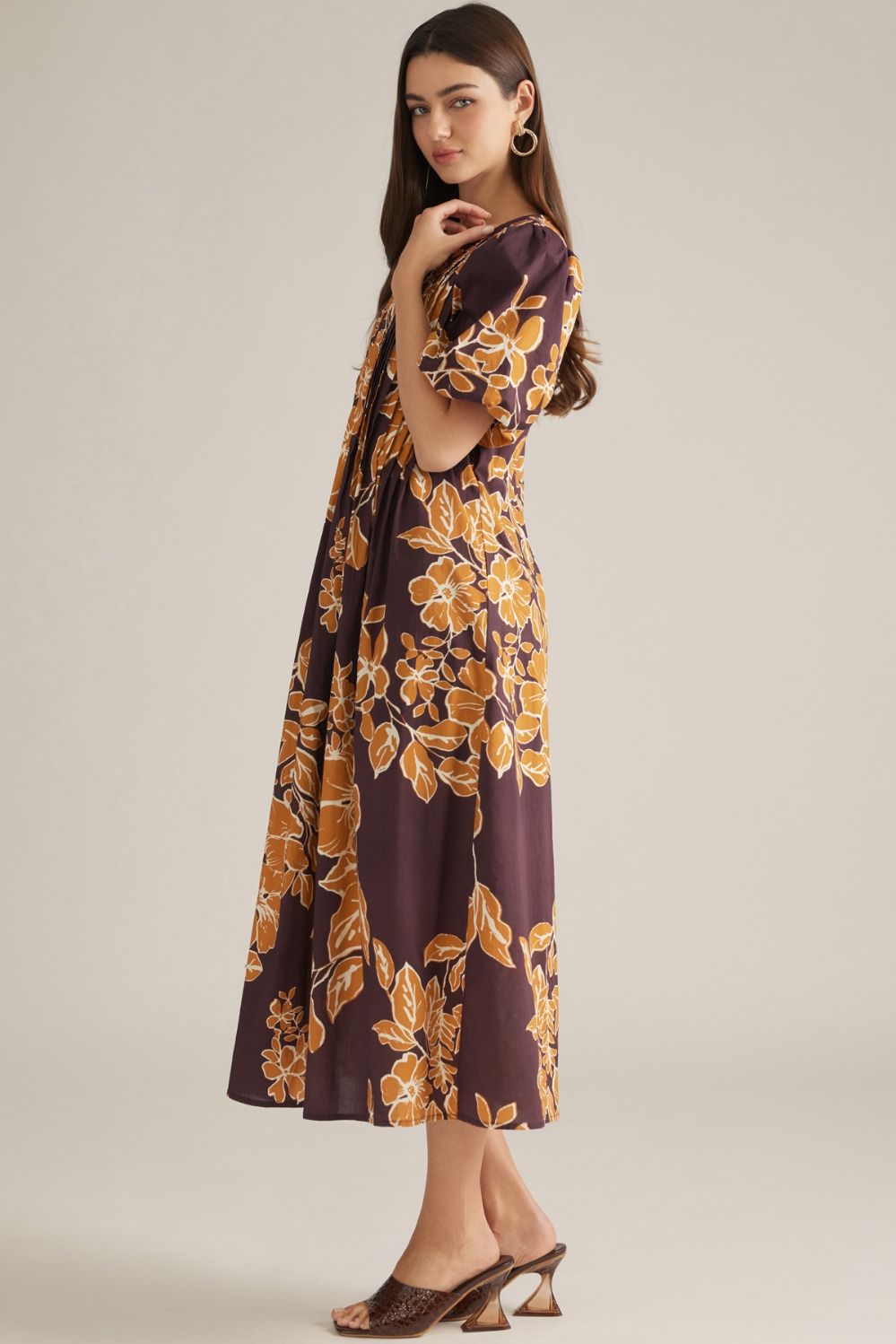 A feminine floral midi dress featuring romantic puff sleeves, a classic round neckline, and elegant front pleating for a beautifully polished silhouette.
