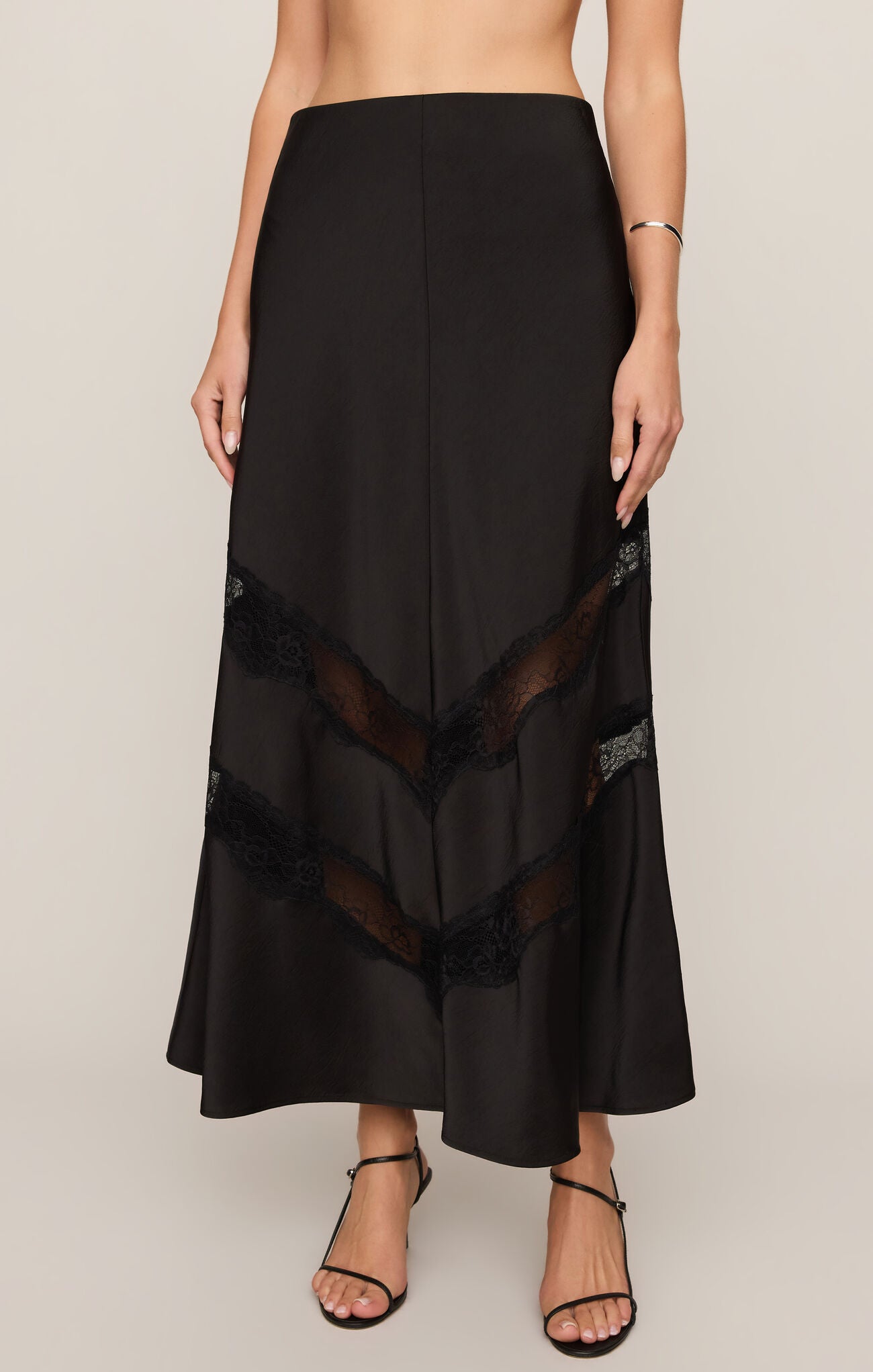 The Kori Lace Inset Skirt combines luxe satin with a flattering high-rise fit and elegant lace detailing for an effortlessly feminine statement.