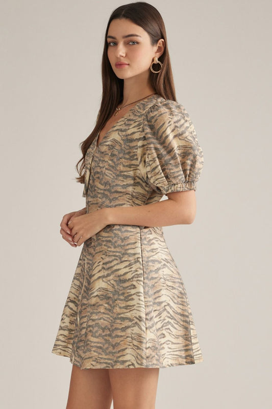 A playful cotton mini dress featuring a flattering V-neckline, short puff sleeves, and an easy front zipper closure in a chic animal print.


