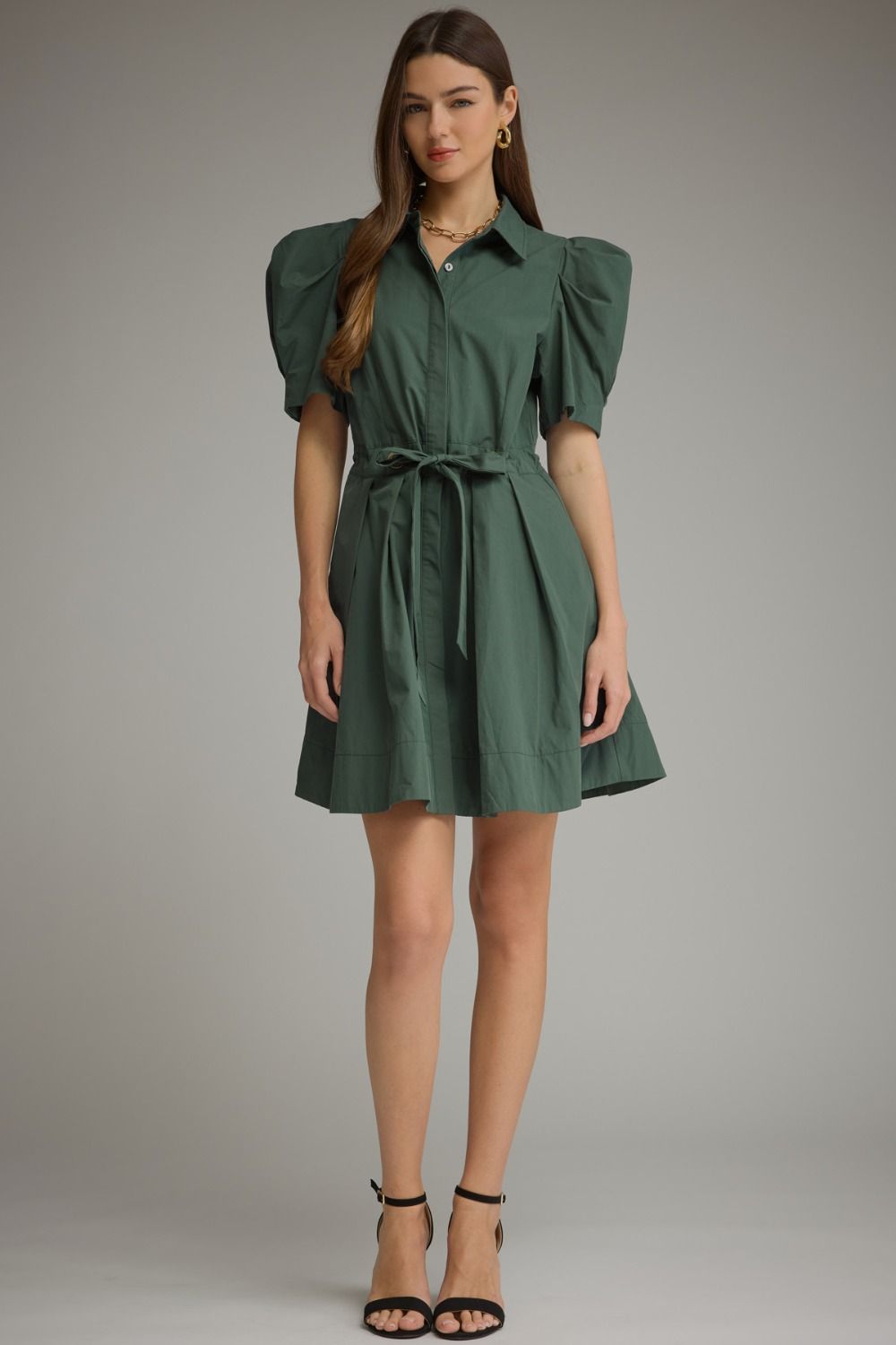 A feminine mini dress featuring playful puff sleeves, a classic shirt collar, waist tie detail, and a beautifully pleated skirt.

