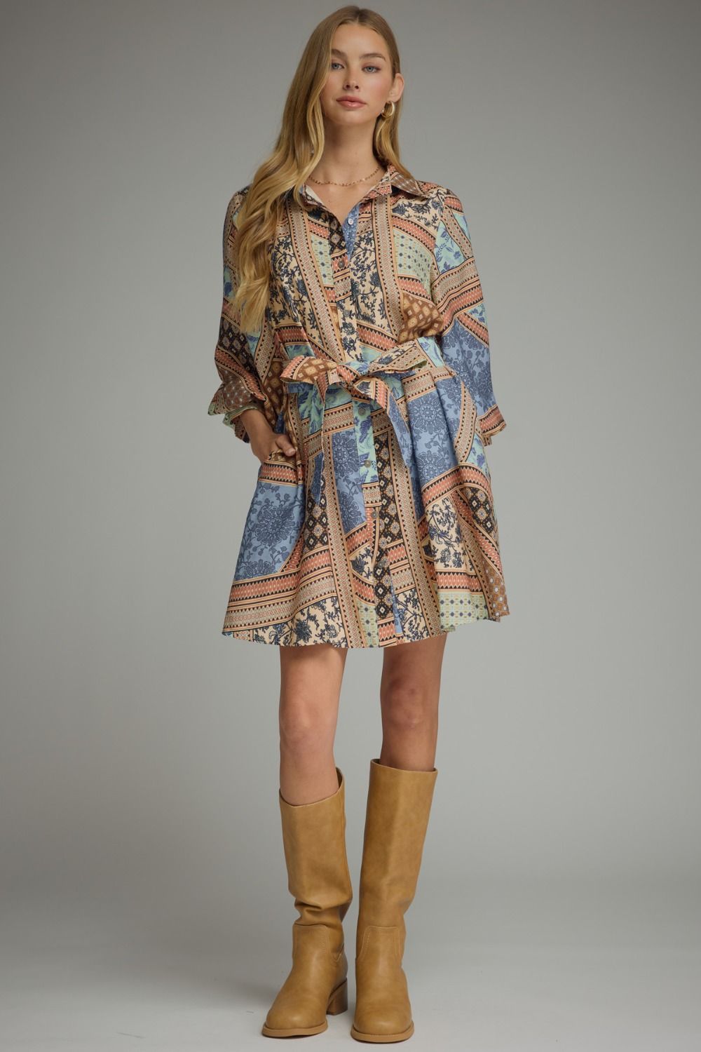 A charming patchwork print mini dress featuring ¾ sleeves, a button-front closure, self-tie waist, and convenient side pockets for effortless everyday style.