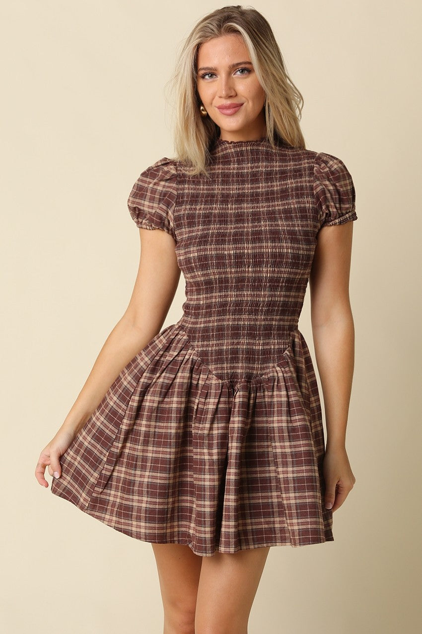 The Rebecca Plaid Smocked Mini Dress pairs timeless plaid with a flattering fit-and-flare silhouette, delicate ruffle sleeves, and a softly gathered skirt.