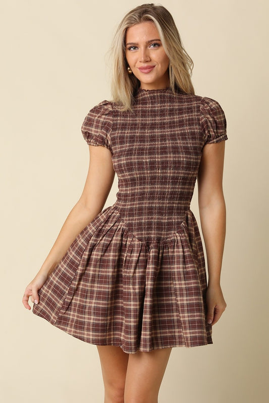 The Rebecca Plaid Smocked Mini Dress pairs timeless plaid with a flattering fit-and-flare silhouette, delicate ruffle sleeves, and a softly gathered skirt.