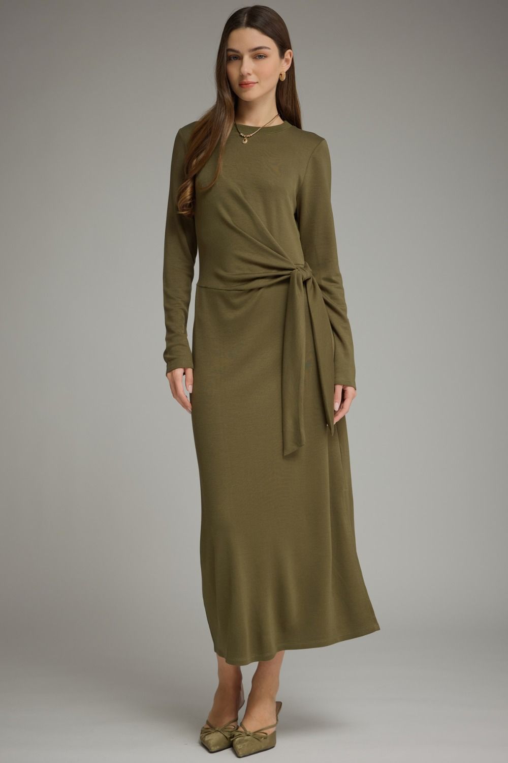 A sleek and effortlessly flattering long sleeve midi dress featuring a soft knit feel, adjustable side-tie waist, and chic side slit.