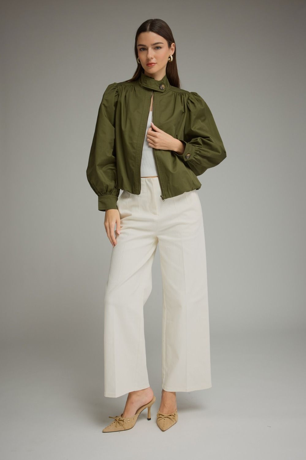 A polished everyday jacket featuring dramatic puff sleeves, a structured stand collar with a unique button closure, and a flattering elastic hem.

