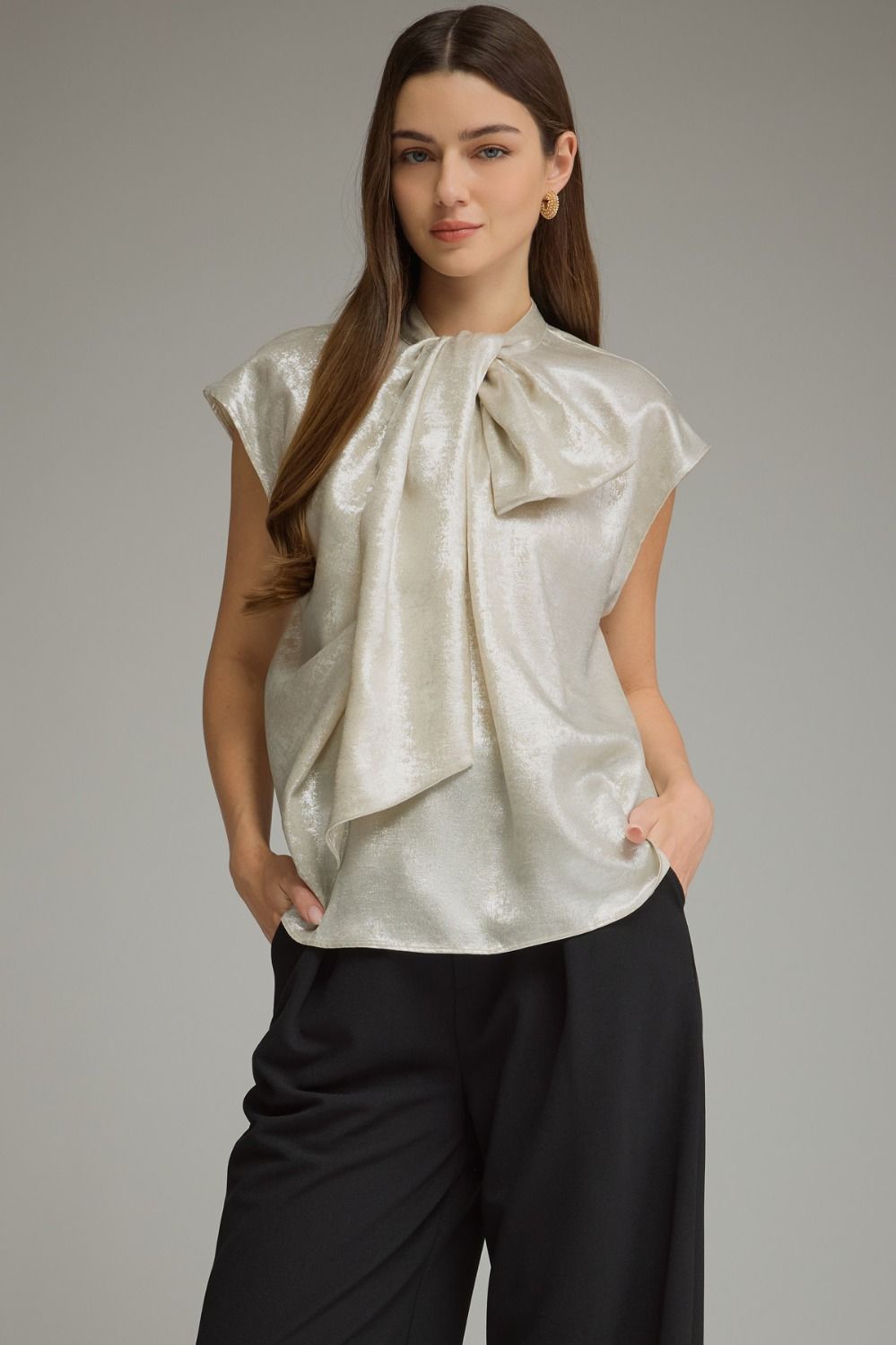 A chic sleeveless-inspired cap sleeve top featuring a high neckline and statement oversized bow for an effortlessly feminine finish.

