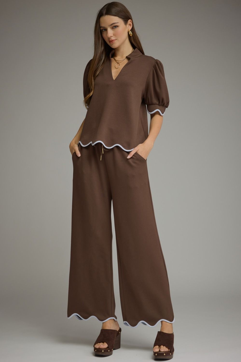 A polished two-piece knit set featuring a feminine scallop-trim top and coordinating drawstring pants for an effortlessly chic look from lounging to lunch.
