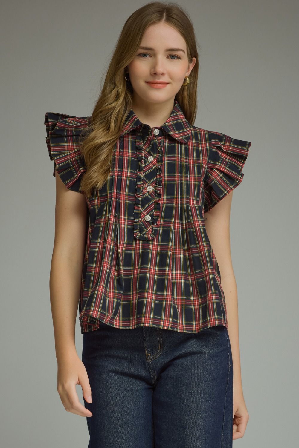 The Della Plaid Ruffle Sleeve Top combines classic plaid with feminine ruffle trim, a button-front placket, and polished collar detail.