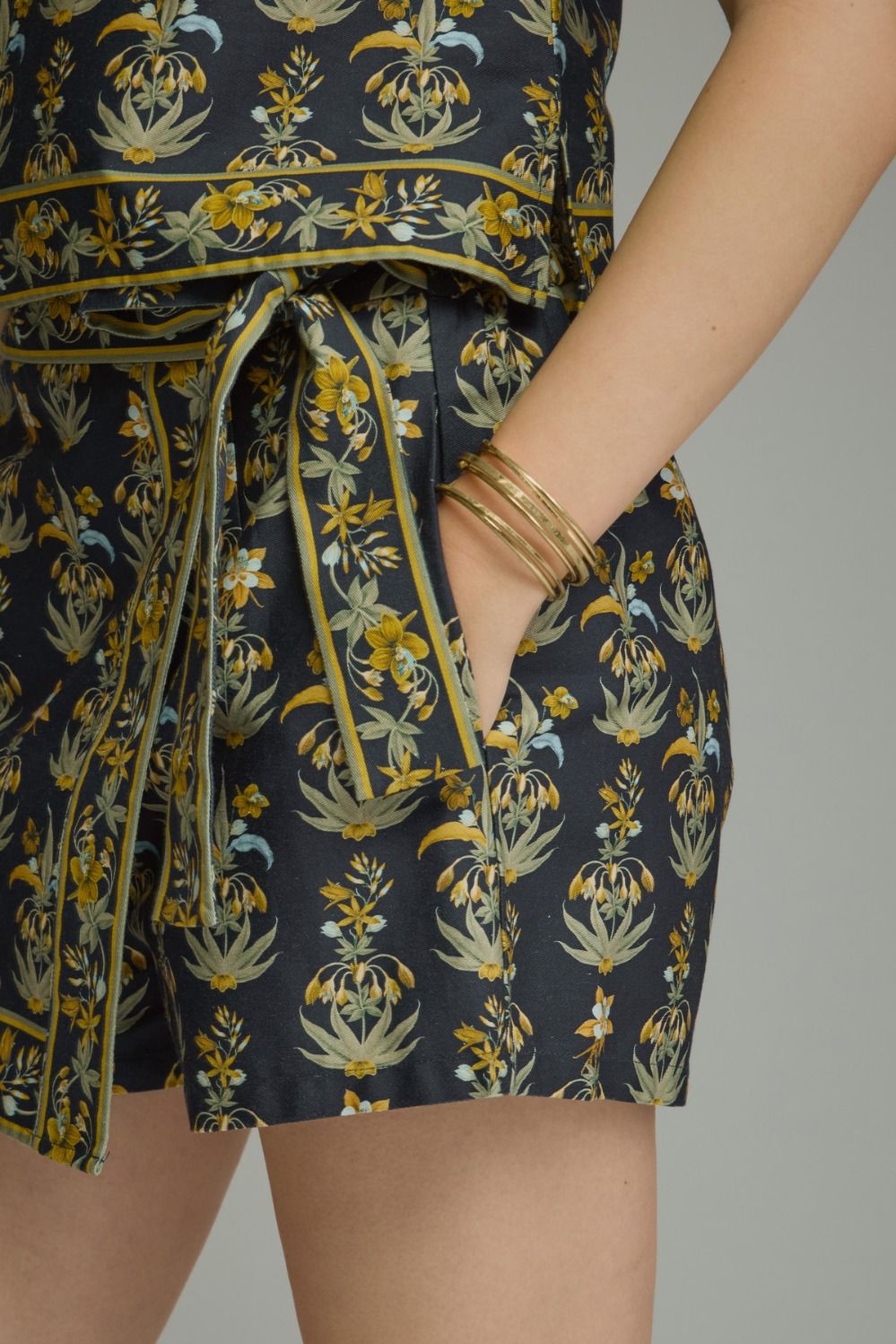 A feminine floral two-piece set featuring a flattering a contrast-trimmed V-neck top and coordinating wrap-front mini skort for an effortlessly polished boutique look.

