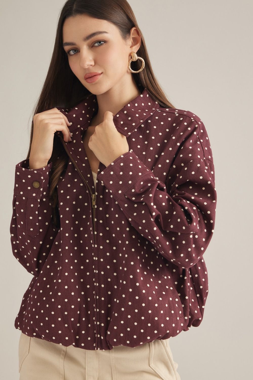 A lightweight polka dot jacket featuring a collared neckline, zip-front closure, and elastic hem for effortless everyday layering.
